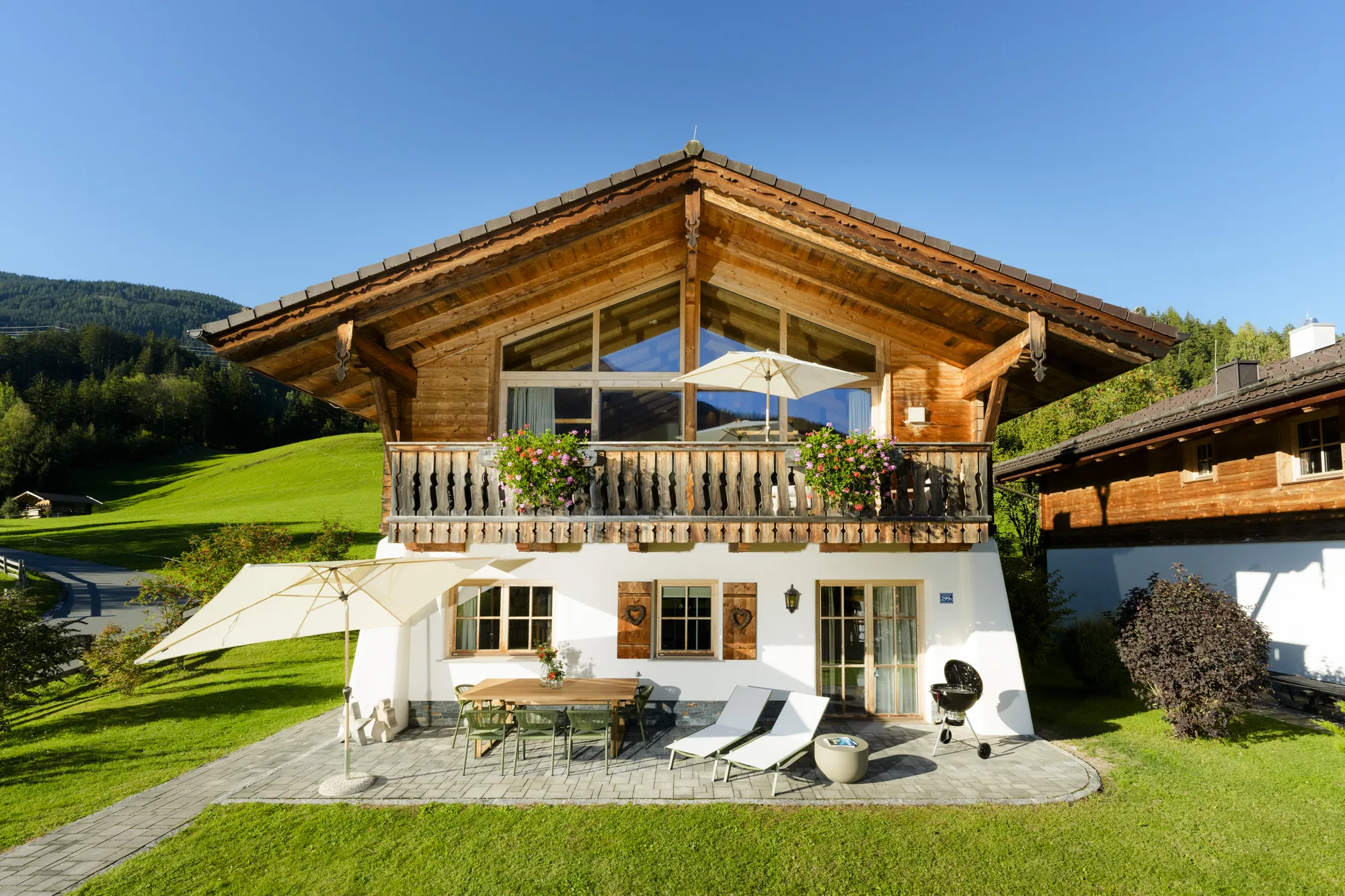 Chalet Gams in summer with wooden balcony, sun terrace, loungers and garden in Neukirchen am Großvenediger