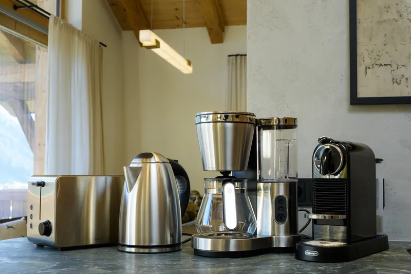 Toaster, kettle, filter coffee machine and capsule coffee machine on the kitchen worktop